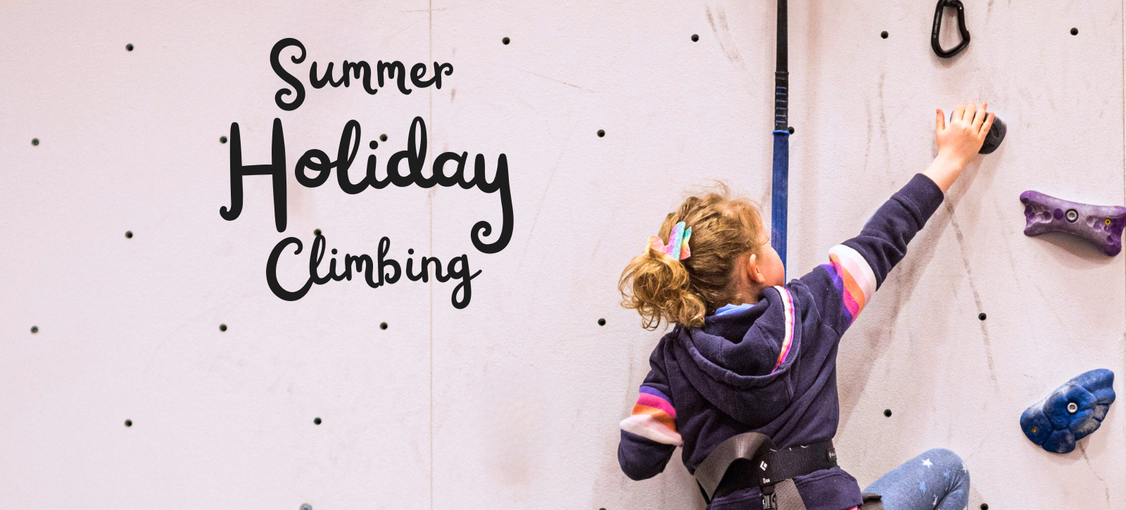 A kid climbing on an auto belay during a kids summer holiday climbing session.