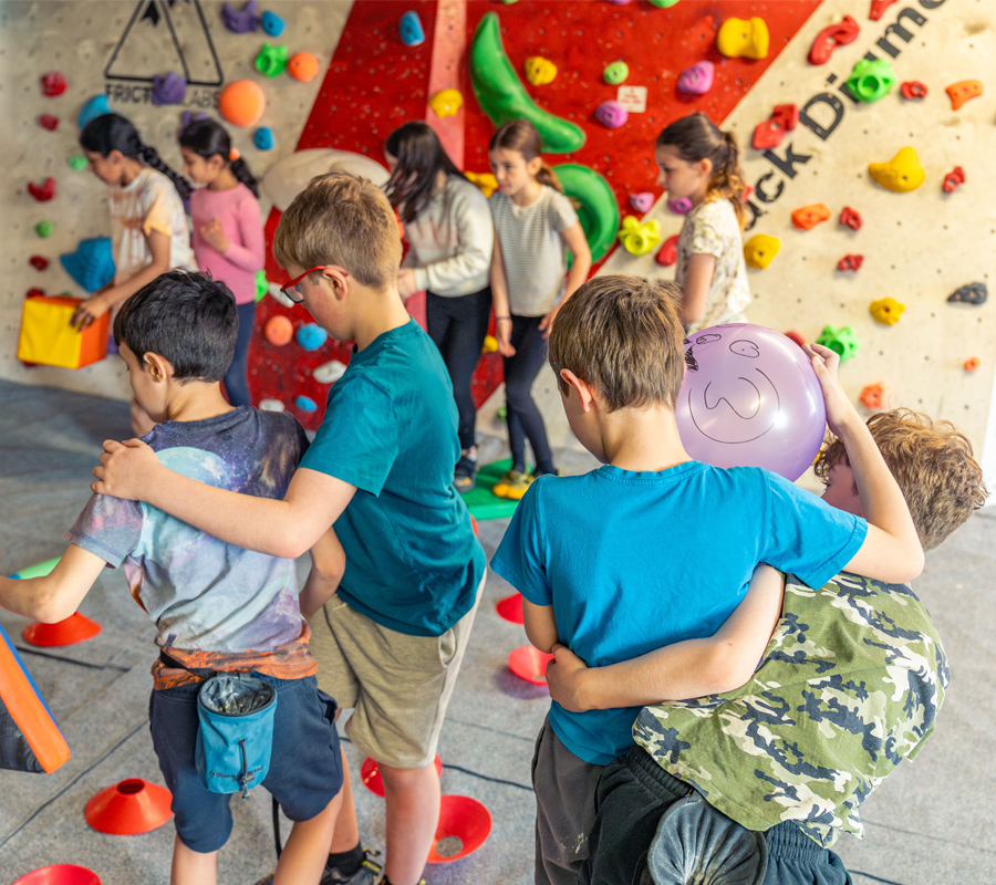 Groups of kids take part in a fun activity where they are interlinked moving around obstacles.