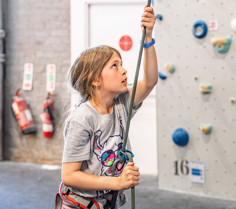 A young girl looks up while belaying